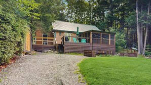 A cabin with a gravel driveway, wooden deck, and a metal roof. - Charming Lakeview House with Deck, Cozy Fireplace and firepit (Rome)