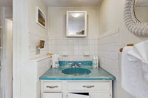 A bathroom with a sink, mirror, and white tiles. - Ocean view home w/ roof deck & patio - great for families, steps to beach (Old Orchard Beach)