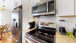 Una cucina moderna con elettrodomestici in acciaio inossidabile, forno integrato e microonde.