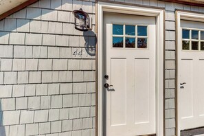 A building with a white door, a mailbox, and a number '44' on the wall.
