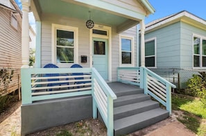Ein Haus mit Veranda, einer blauen Tür und der Hausnummer 3527.