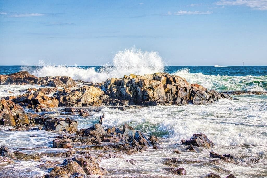 A rocky shoreline with waves crashing against the rocks.