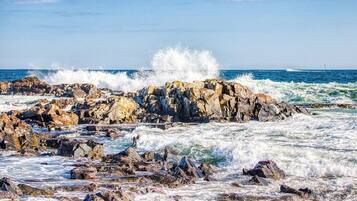A rocky shoreline with waves crashing against the rocks.