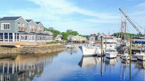 A marina with boats docked, a waterfront building, and a clear sky.