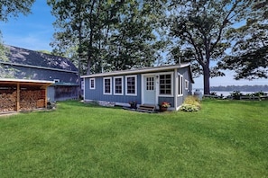 Ein kleines Haus mit Veranda, Garage und Rasen.