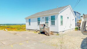Een gelijkvloers huis met een veranda, een kleine trap en een helder uitzicht op het omliggende landschap.