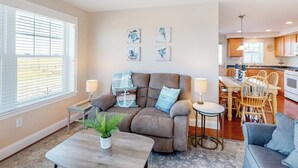 Een woonkamer met een bank, salontafel en kunstwerk aan de muur.
