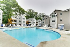A swimming pool with lounge chairs and a wooden deck. - Charming condo with outdoor pool, private washer/dryer, partial estuary view (Wells)