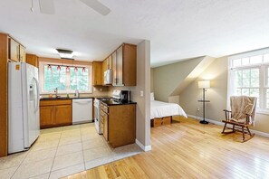 Eine kleine Küche mit Holzausstattung, einem Kühlschrank und einem Herd.