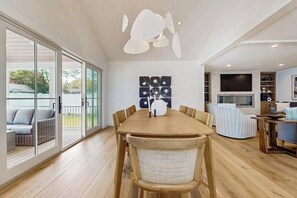 Ein geräumiger Essbereich mit Holztisch und -stühlen, einem großen Fenster mit Blick und einer modernen Deckenleuchte.