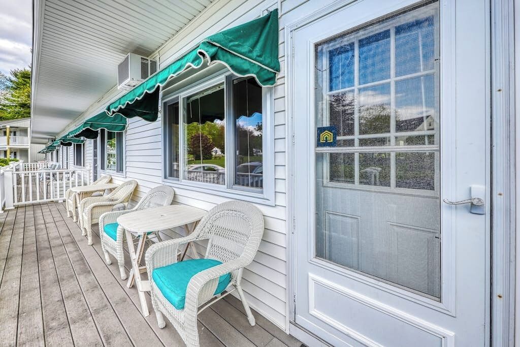 A porch with wicker furniture and a green awning.