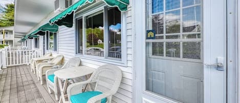 A porch with wicker furniture and a green awning.
