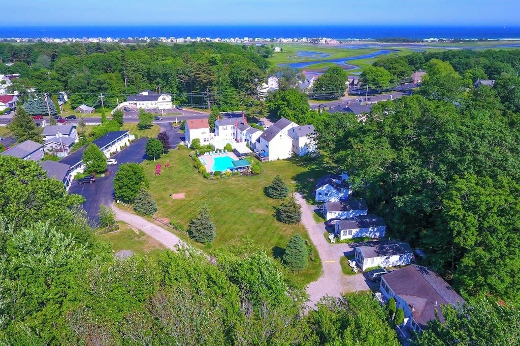 A residential area with houses, a swimming pool, and a view of the ocean.