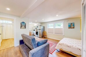 Ein modernes Interieur mit einer Couch, einem Bett, einer Küche und einem Essbereich.