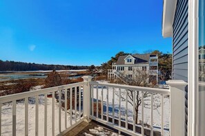 Zona residencial con una casa, una terraza de madera y vistas a un río.