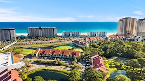Ein Resort mit mehreren Gebäuden, einem Golfplatz und einem Strand.