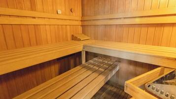 Una sauna con panche di legno e una panca con poggiapiedi.