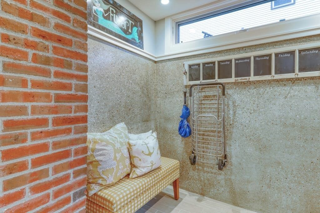 A bathroom with a checkered bench, a towel rack, and a calendar on the wall.