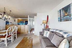 Ein Wohnzimmer mit einer Couch, einem Holztisch und einem Essbereich mit Stühlen und einem Tisch.