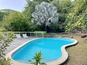 A swimming pool with a curved edge, surrounded by greenery and a white fence. - Koala 2, elegant studio with sea view in Anse Marcel (Anse Marcel)