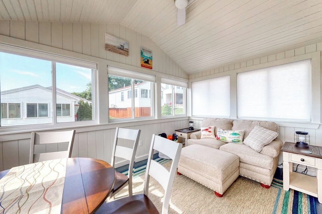 A cozy room with a dining table, chairs, a sofa, and a small side table.