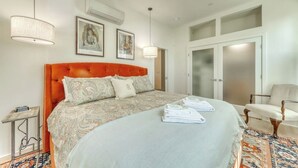 Une chambre à coucher avec un grand lit, deux tables de chevet, une chaise et une armoire.