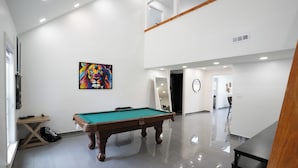 A spacious indoor area with a pool table, a painting on the wall, and a wooden bench. - Glam Luxe Modern Stay Near Uptown Charlotte (Charlotte)