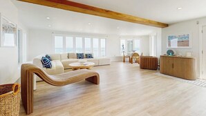 A spacious living area with a wooden bench, a sofa, and a cabinet. - Coastal gem on the water with beach access, gorgeous views & spacious layout (Wells)