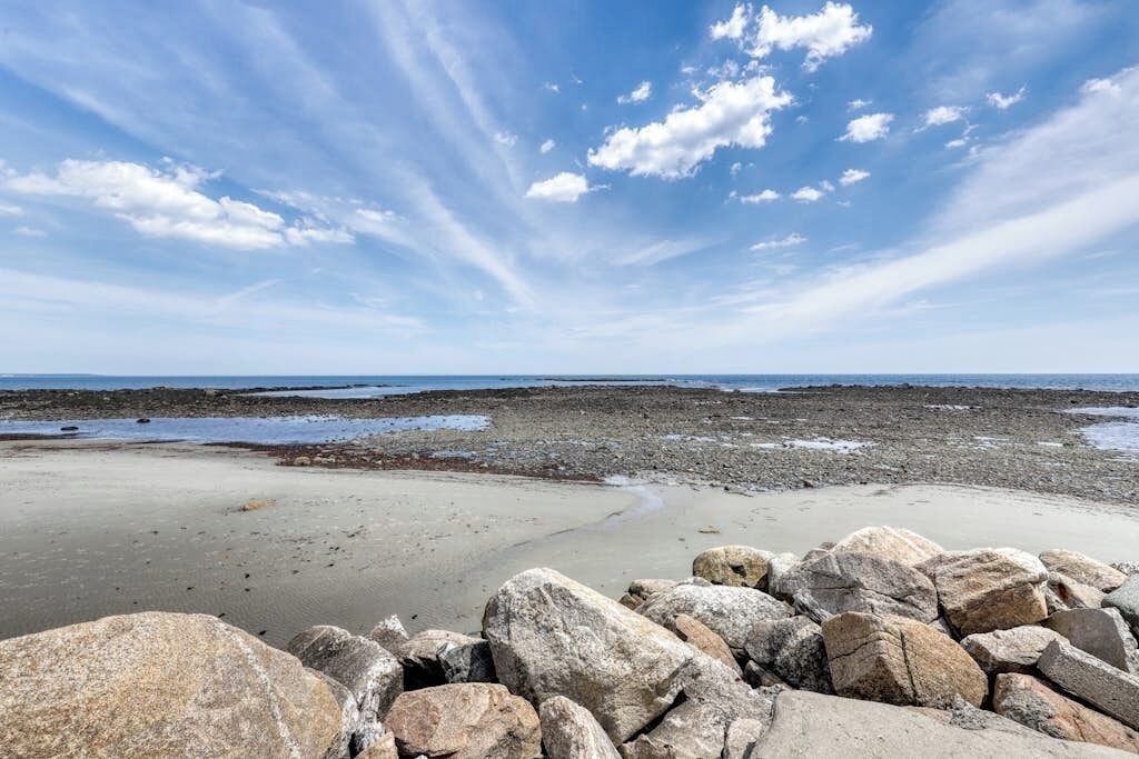 Una spiaggia rocciosa con cielo sereno.
