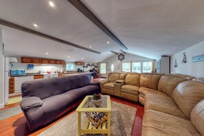 Ein geräumiger Wohnbereich mit einer Couch, einem Couchtisch und einer Ledersitzgruppe.