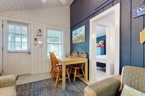 A room with a dining table, chairs, a bed, and a small kitchenette. - Cute cottage with screened porch & shared pool - walk to Ogunquit Beach (Wells)