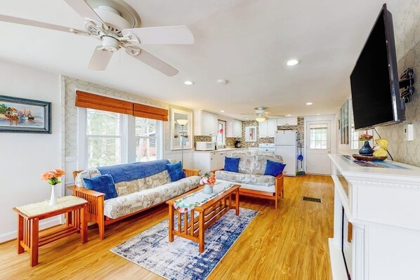 A living room with a sofa, coffee table, and a TV mounted on the wall.