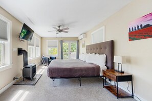 Ein Schlafzimmer mit Bett, Heizung, Fernseher, Deckenventilator und einem Bild an der Wand.