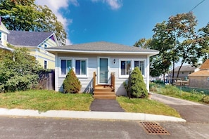 A single-story house with a front porch, a small front yard, and a visible front door.