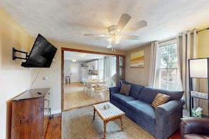 A living room with a sofa, coffee table, and a ceiling fan.