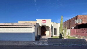 A building with a garage, a red rental sign, and a cactus in the front yard. - Special house to spend a pleasant time (El Caballito)