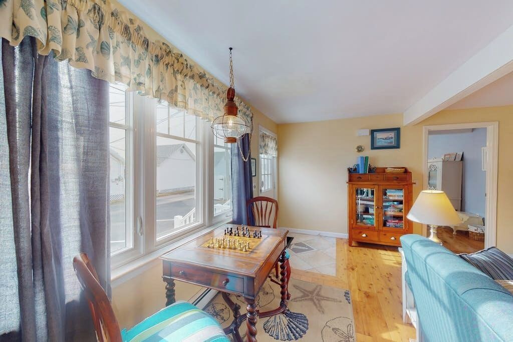 A living room with a chessboard, a wooden cabinet, a sofa, and a lamp.