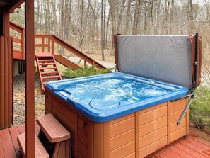 A hot tub on a wooden deck with a wooden staircase leading up to it. - Charming Hillside Retreat with Hot Tub, Firepit, and Spacious Deck (Wells)