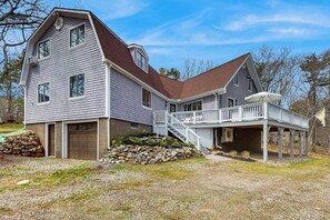 A two-story house with a covered porch, a stone foundation, and a garage.
