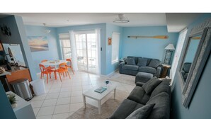 Ein Wohnzimmer mit einer Couch, einem Couchtisch und einem Essbereich mit Stühlen.