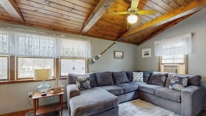 A cozy living room with a sectional sofa, wooden ceiling beams, and a ceiling fan. - Gorgeous dual-unit, perfect for large groups Dogs are welcome (York)