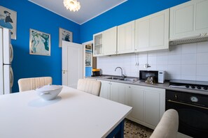 A kitchen with white cabinets, a microwave, a stove, and a sink. - 106. Oscar, Villa On The Lake (Piemonte)