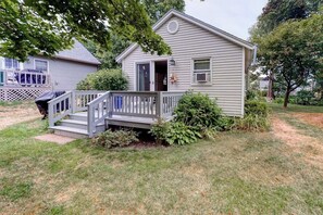 A single-story house with a front porch, a small staircase, and a covered outdoor area.