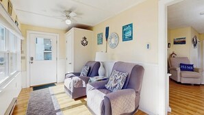 A living room with two sofas, a coffee table, and a door leading to another room.