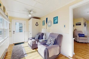 A living room with two sofas, a coffee table, and a door leading to another room.