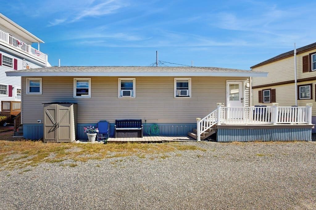 A single-story house with a front porch, a garage door, and a small deck.