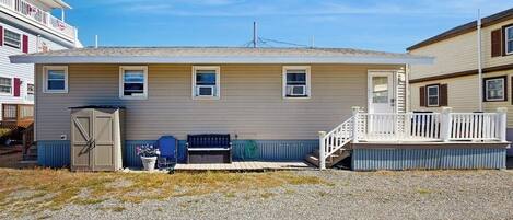 A single-story house with a front porch, a garage door, and a small deck.