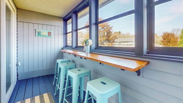 A kitchen with a wooden countertop, bar stools, and large windows. - Updated condo 1 mile to beach w/pool, hot tub, tennis & access to EV chargers! (Wells)
