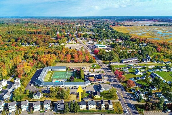 An aerial view of a residential area with houses, a large school building, and a sports field.
