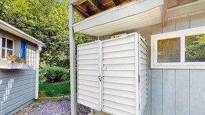 Una casa con porche cubierto, puerta de garaje y una ventana con persianas.